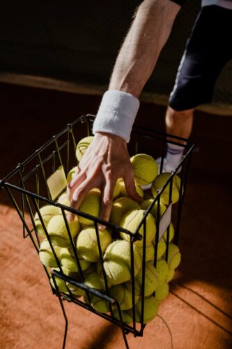 a person holding green tennis balls