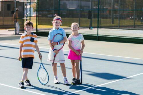 kids smiling on the tennis court